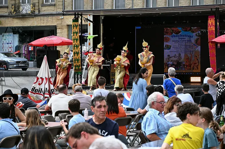 Tancerki w złotych kostiumach tańczą na scenie podczas festiwalu tajskiej kultury