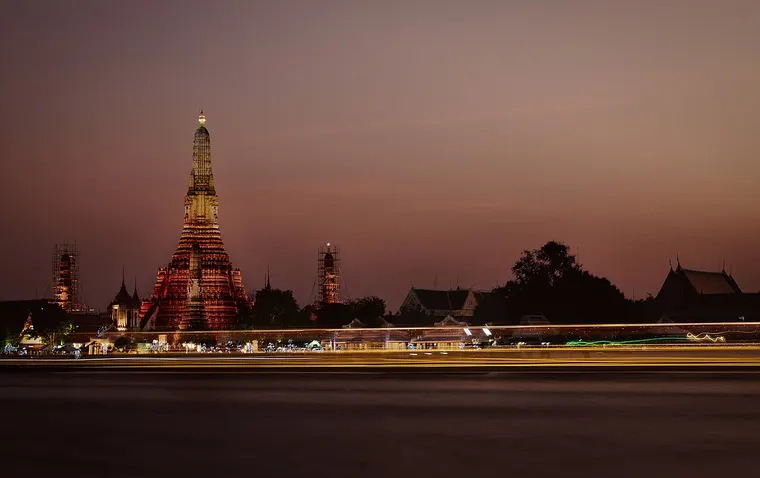 Oświetlona świątynia Wat Arun nad rzeką Chao Phraya o zmierzchu