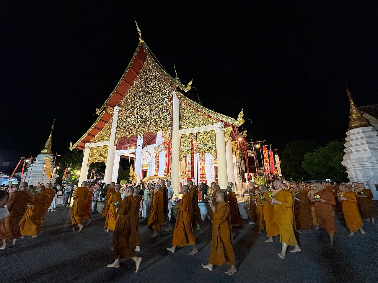 Mnisi obchodzą świątynię z procesją wian thian w noc Asalha Puja, Wat Chedi Luang w Chiang Mai