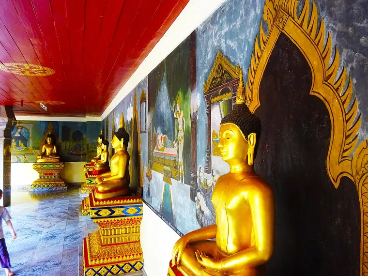 Złote posągi Buddy w galerii świątyni w Chiang Mai