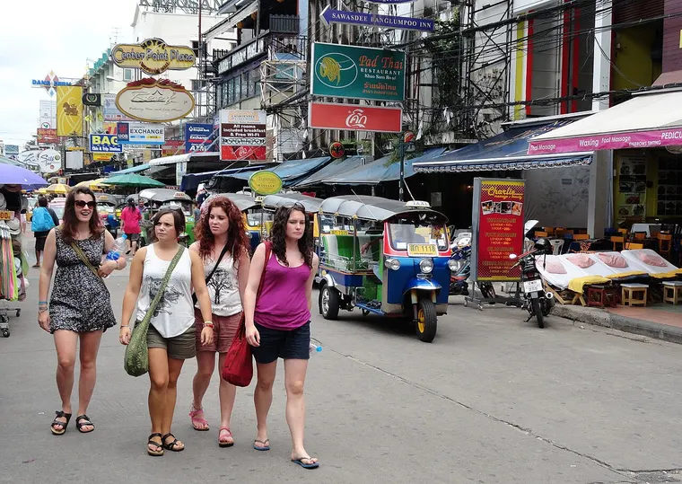 Turyści z plecakami na ulicy Khao San w Bangkoku