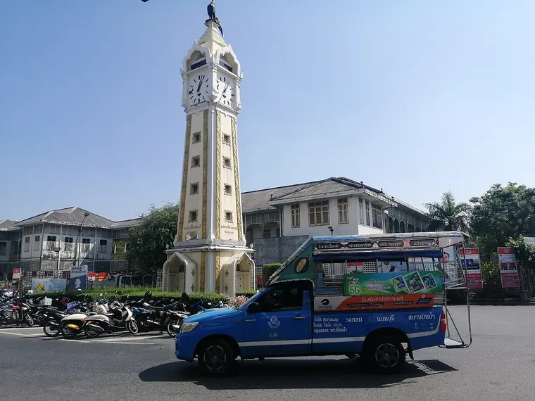 Wieża zegarowa w Nonthaburi i niebieska taksówka songthaew