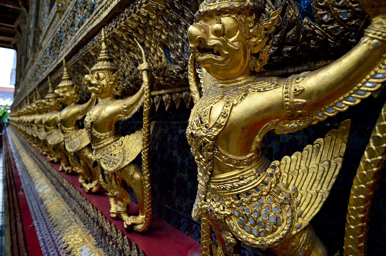 Złote garudy wzdłuż ściany botu Wat Phra Kaew w Bangkoku