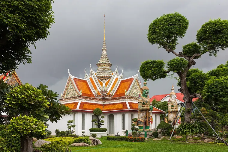 Świątynia w kompleksie Wat Arun w Bangkoku wśród przystrzyżonych drzew