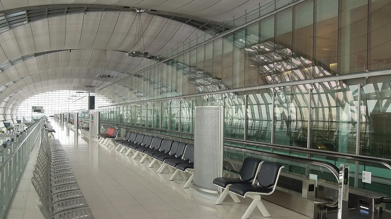Hala odlotów z rzędami krzeseł na lotnisku Suvarnabhumi w Bangkoku