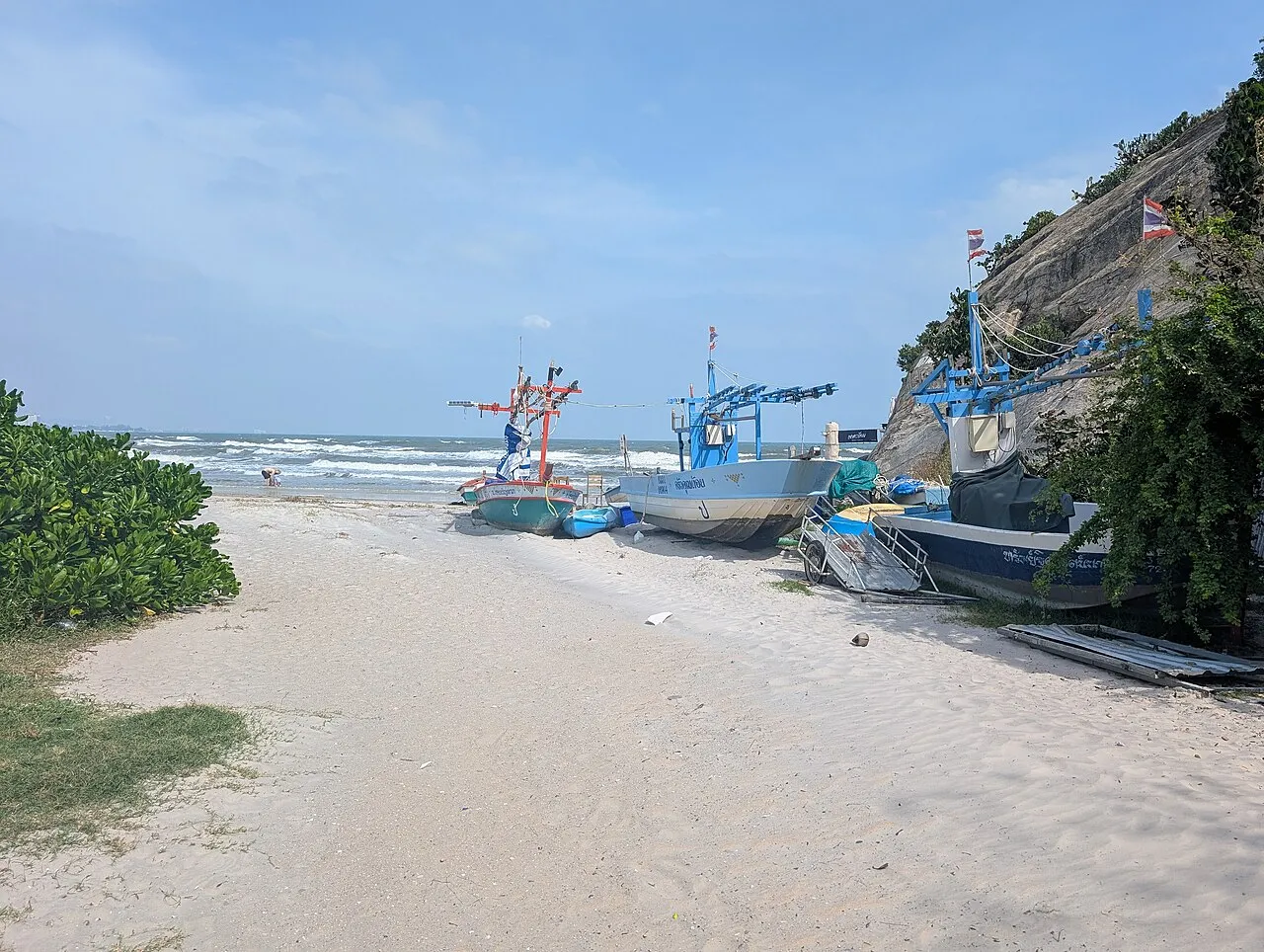 Plaża w Hua Hin z łodziami rybackimi i skałami