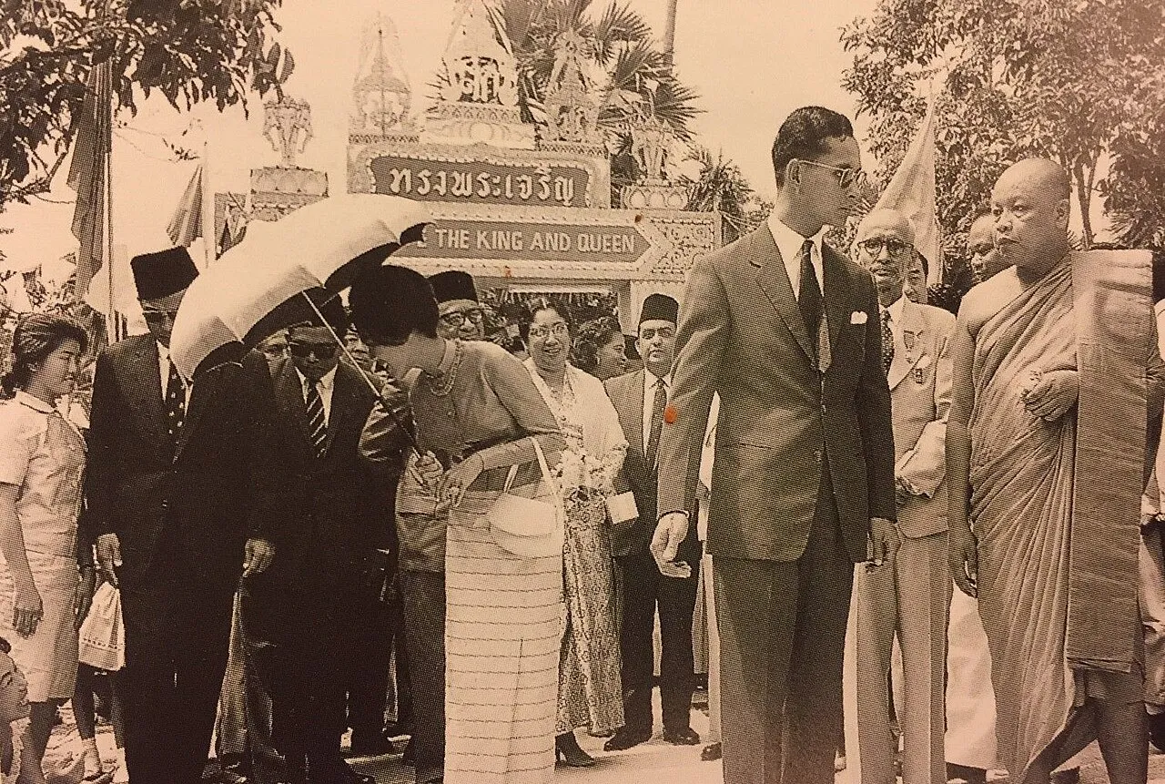 Król Bhumibol i królowa Sirikit wśród tłumu podczas wizyty w świątyni Wat Chetawan, 1962