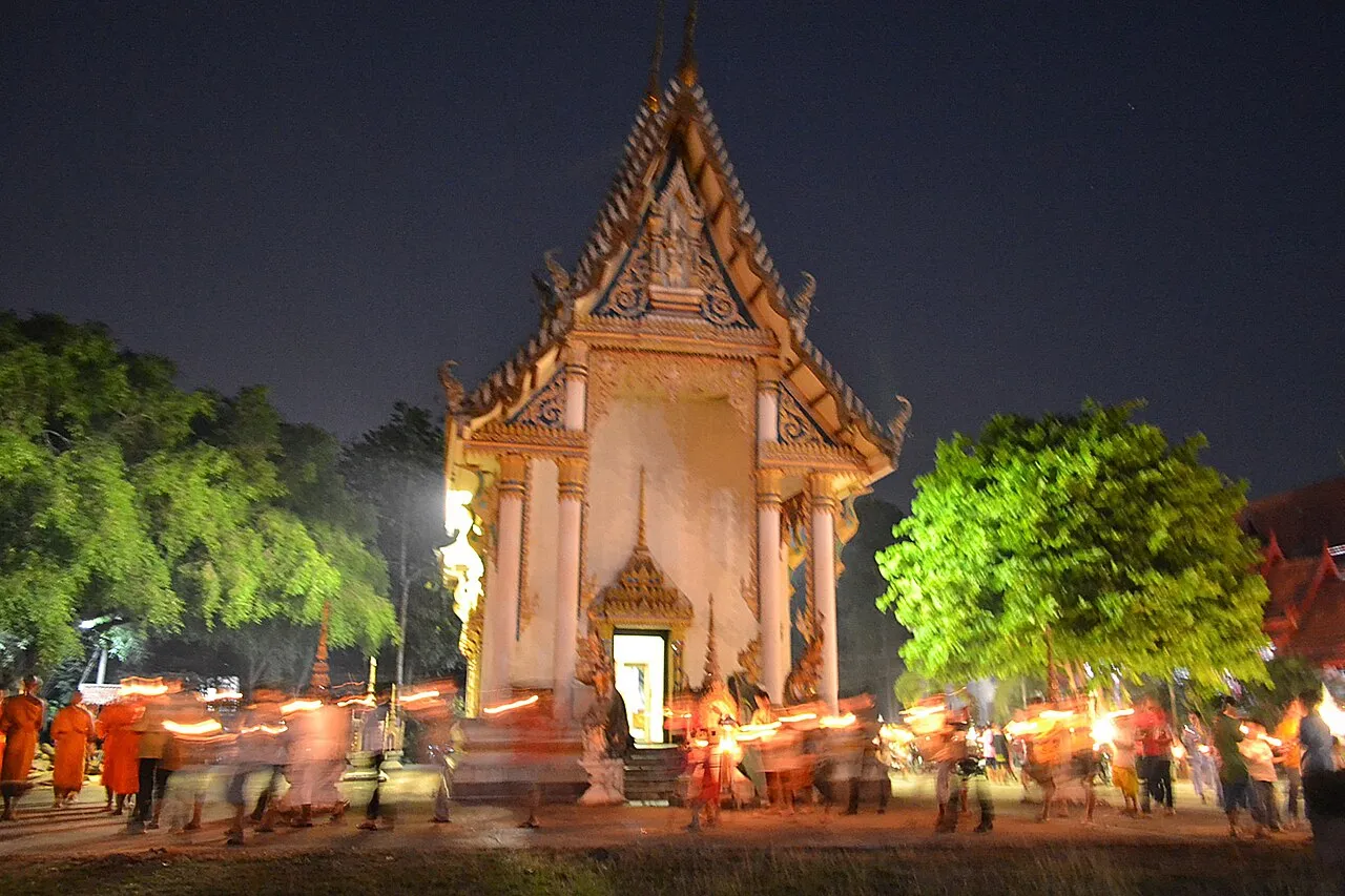 Wierni ze świecami okrążają kaplicę Wat Khung Taphao w noc Makha Bucha