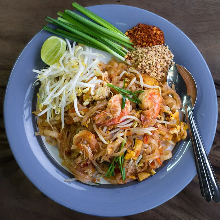 Talerz pad thai z kiełkami fasoli, szczypiorkiem i limonką