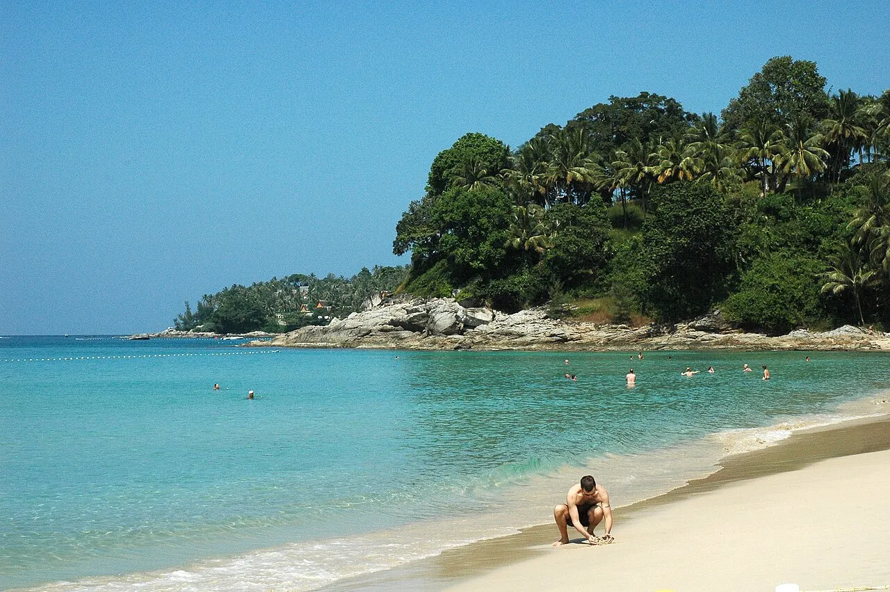 Piaszczysta plaża Surin w Phuket z zalesionym przylądkiem