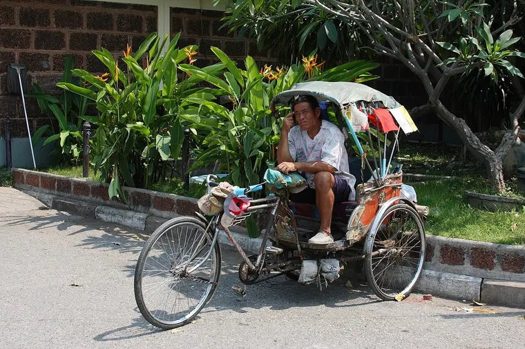 Riksza rowerowa samlor z kierowcą odpoczywającym w Lopburi