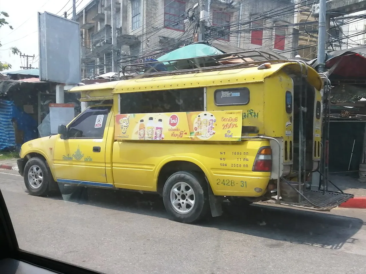 Żółty songthaew, czyli pikap z ławkami na pace, na ulicy w Chiang Mai