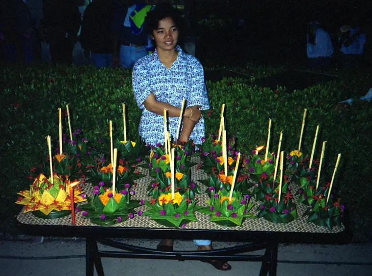 Sprzedawczyni krathongów ozdobionych kwiatami i świeczkami podczas Loi Krathong w Sukhotai