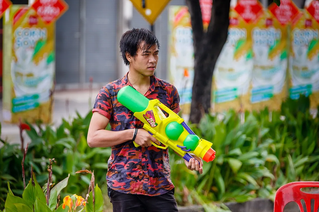 Młody mężczyzna z pistoletem na wodę podczas święta Songkran w Chiang Mai