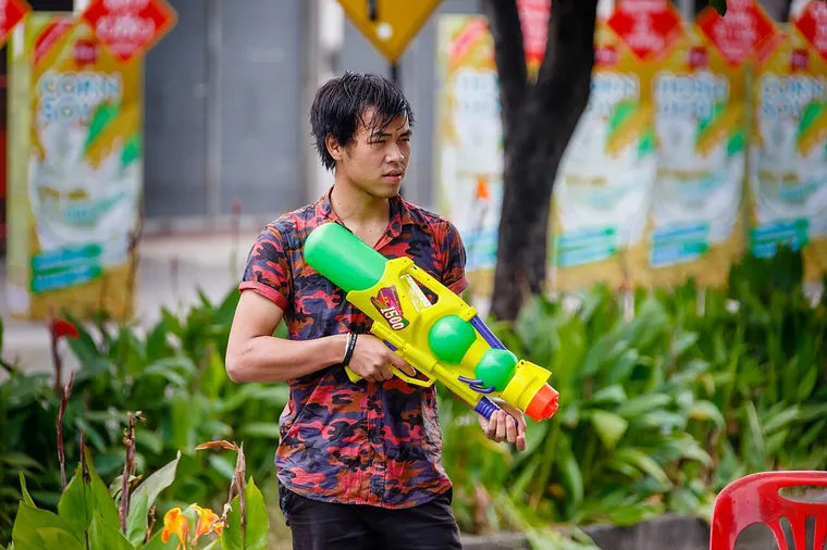 Młody mężczyzna z pistoletem na wodę podczas Songkran w Chiang Mai