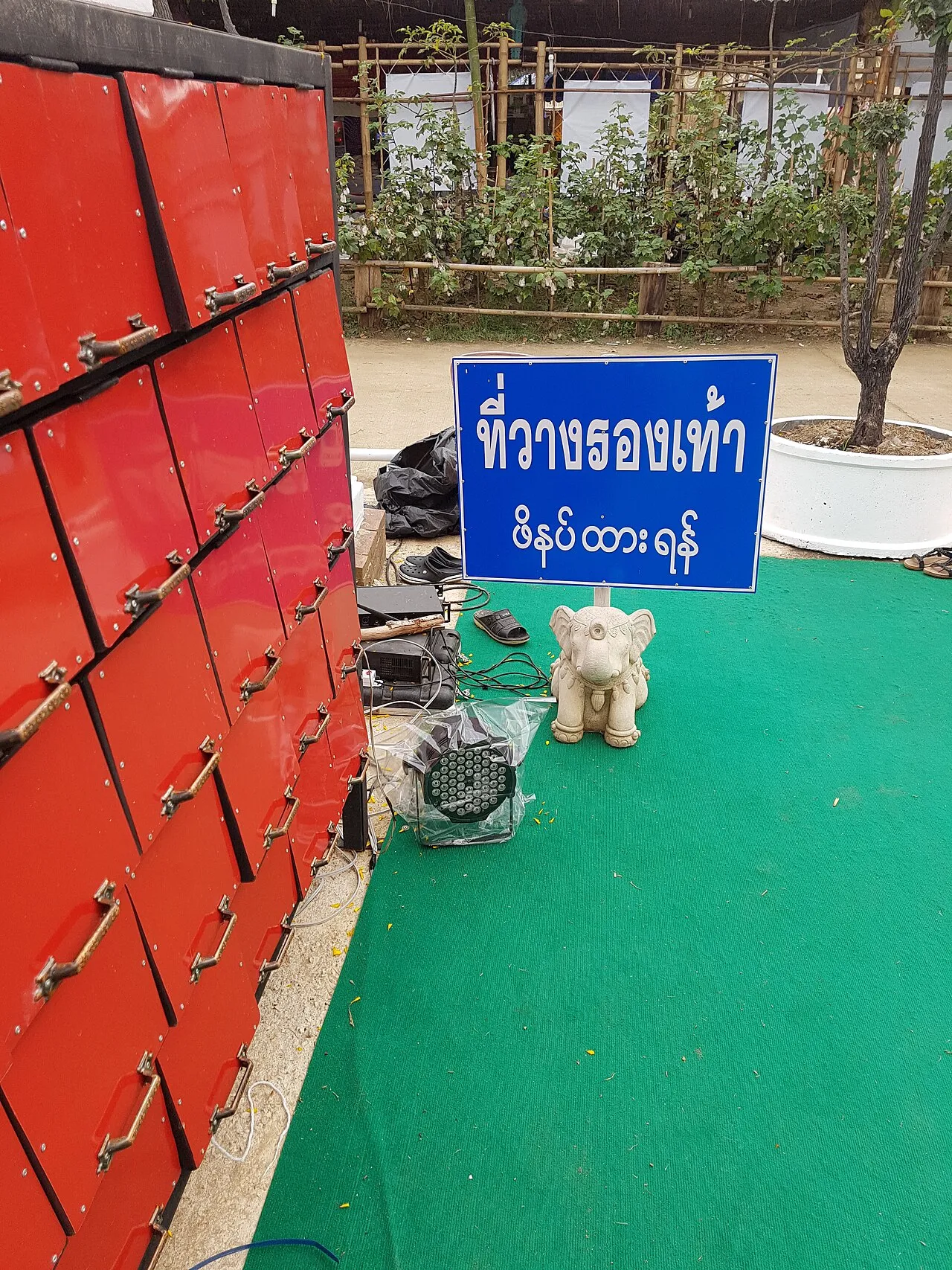 Tabliczka z prośbą o zostawienie butów przed wejściem na teren świątyni w Chiang Rai