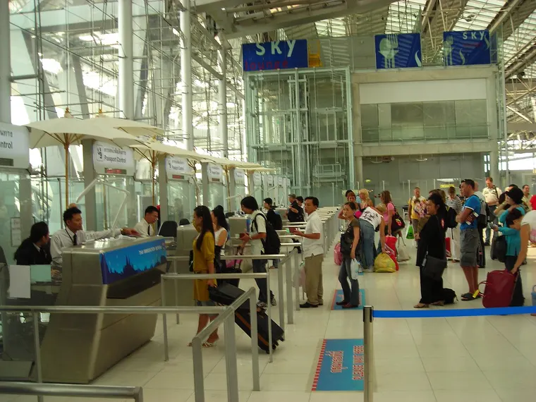 Podróżni w kolejce do stanowisk kontroli paszportowej na lotnisku Suvarnabhumi w Bangkoku