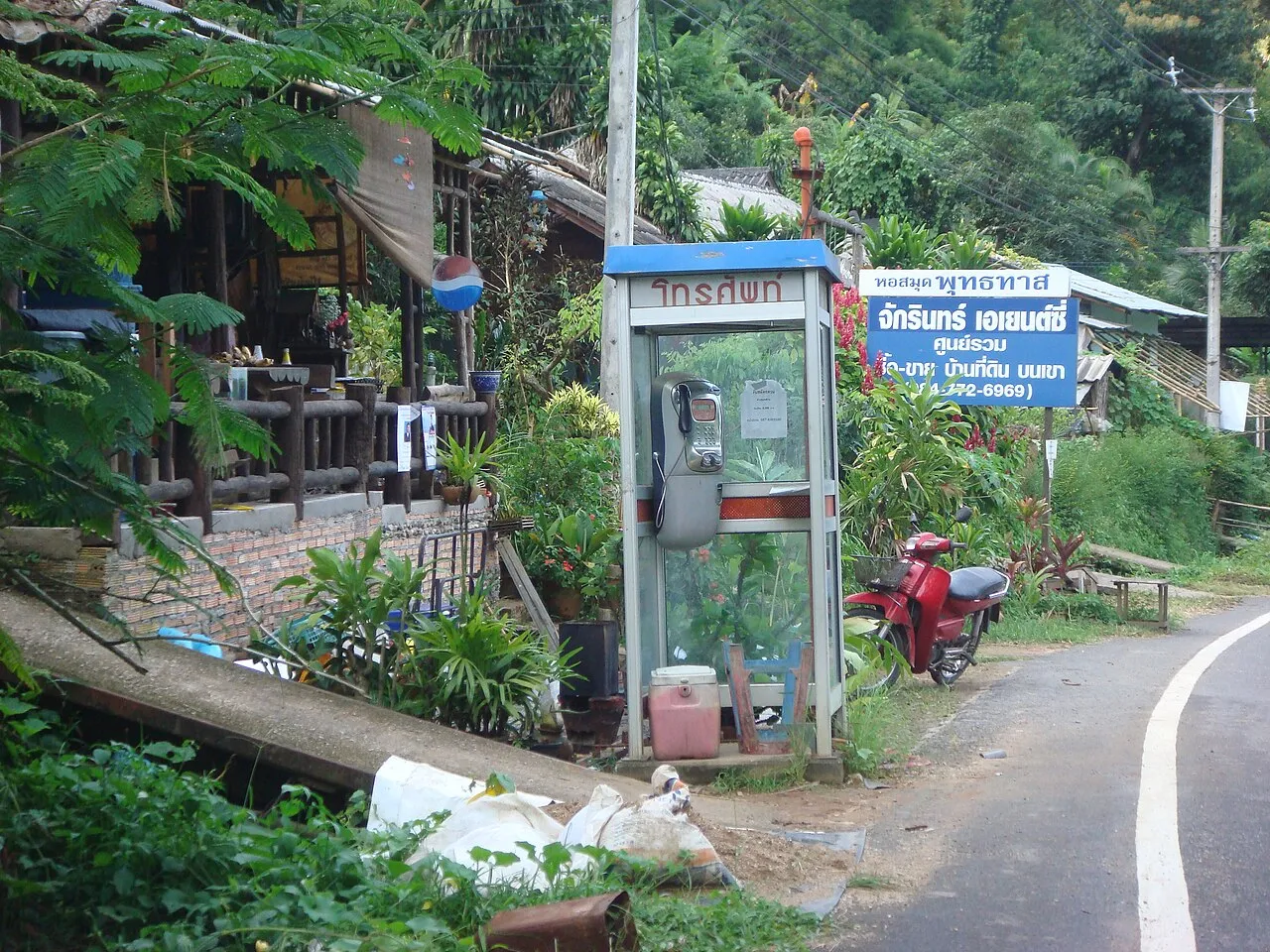 Zielona budka telefoniczna przy drodze w prowincji Chiang Mai