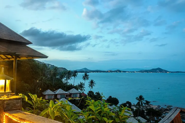 Widok z tarasu hotelu na zatokę Chaweng i palmy na wyspie Ko Samui o zmierzchu