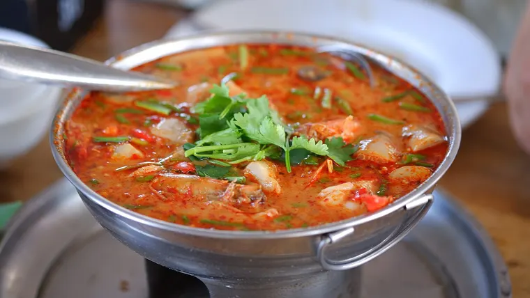 Tajska zupa tom yum z krewetkami w metalowym naczyniu